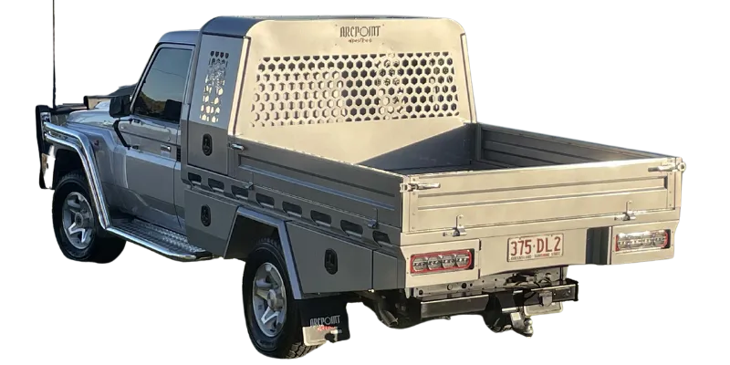 A silver pickup truck fitted with a beige metal utility bed cover and tailgate, shown from a rear three-quarter angle on a white background.