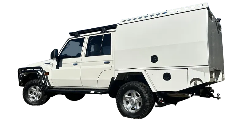 A white off-road utility vehicle with a large white box camper body mounted behind it, shown on a plain white background. The vehicle has black tires, black trim, and roof racks.
