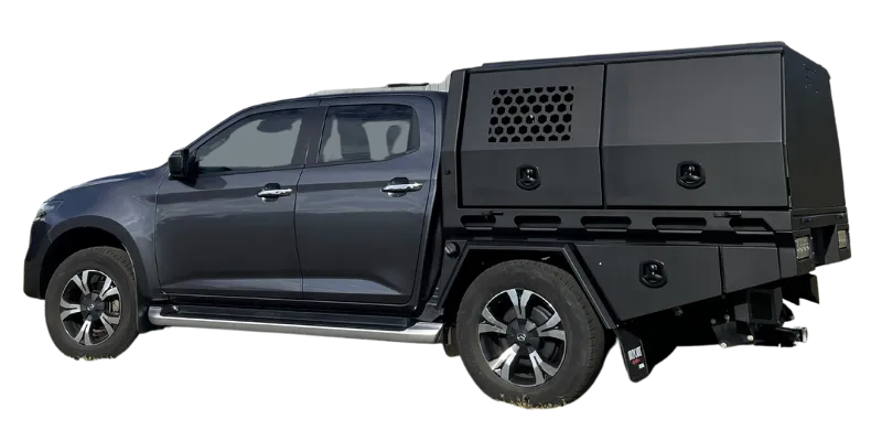 A dark gray pickup truck with a large black hardtop camper body mounted on the bed, shown from a side profile view against a plain white background.
