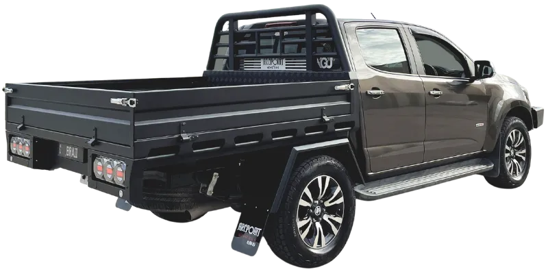 A dark gray pickup truck shown from a rear three-quarter angle, fitted with a black metal tonneau-style bed cover and roll bar. The truck is photographed on a plain white background.